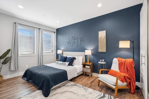 a bedroom with blue walls and a bed and a chair at The Charm 2BD In the Heart of Magnolia in Fort Worth