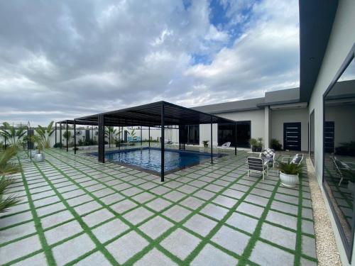 a patio with a pool and a pavilion at لامور فيلا in Sohar