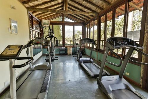 a gym with several tread machines in a room at Pousada do Quilombo in São Bento do Sapucaí
