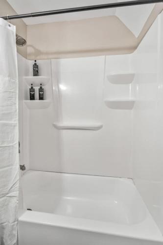a white bathroom with a shower and a white curtain at AT and T Walkable 1BD unit Live the Excitement in Arlington