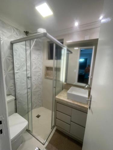 a bathroom with a shower and a toilet and a sink at Apartamento Aconchegante e completo em Uberaba J & JF I in Uberaba