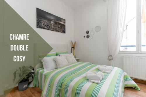 a bedroom with a bed with towels on it at Le Petit Cosy de la Gare - Wifi in Drancy