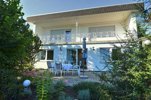 una casa con mesa, sillas y sombrilla en Ferienwohnung Idyll Mit Loggia Und Garten, en Welferode