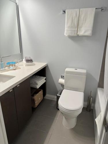 a bathroom with a white toilet and a sink at Cozy Studio in the heart of Yorkville in Toronto