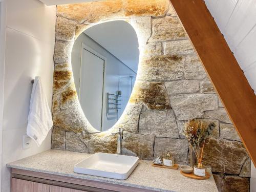 a bathroom with a stone wall and a sink at Cabana com piscina e vista de tirar o fôlego! in Maria da Fé