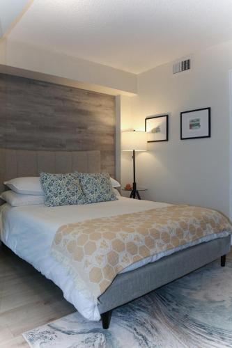 a bedroom with a large bed with a wooden headboard at Cozy Studio in the heart of Yorkville in Toronto