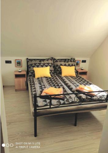 a bed with two yellow pillows in a room at BJ szállás in Zalaegerszeg
