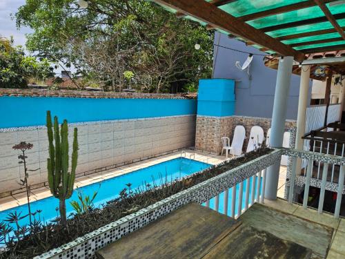 a swimming pool in the backyard of a house with a cactus at Hotel Recanto do Sol in Cananéia