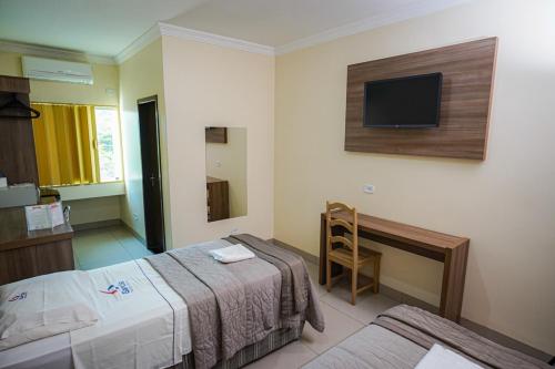 a hotel room with two beds and a tv on the wall at Garcia Palace Hotel in Sinop