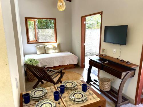 a room with a bed and a table with a piano at Pipa Moaina Hale in Pipa