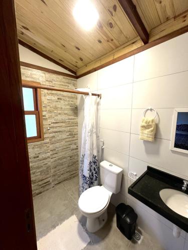 a bathroom with a toilet and a sink at Pipa Moaina Hale in Pipa