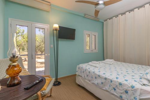 a bedroom with a bed and a desk and a table at Olive House in Kalamaki