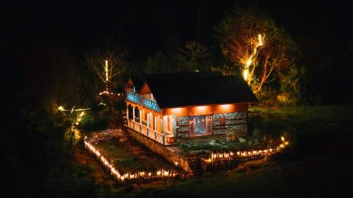 a house lit up at night with lights on it at Selah by soho house in Jibhi