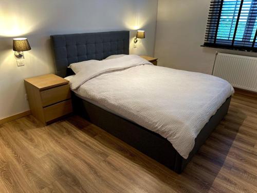 ein Schlafzimmer mit einem großen Bett mit blauem Kopfteil in der Unterkunft Vakantiewoning rand Brugge in Jabbeke