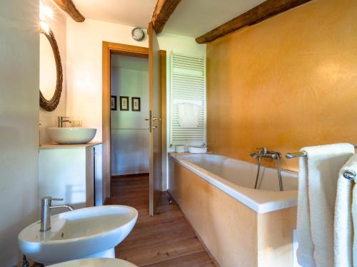 ein Badezimmer mit Badewanne und Waschbecken in der Unterkunft La Foresteria at Casaforte Bergum by the Gates of Cividale del Friuli 