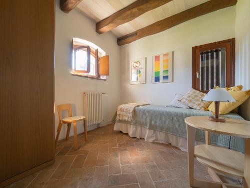 ein Schlafzimmer mit einem Bett, einem Tisch und einem Stuhl in der Unterkunft La Foresteria at Casaforte Bergum by the Gates of Cividale del Friuli 