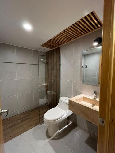 a bathroom with a toilet and a sink at Casa Layu Oaxaca in Oaxaca City