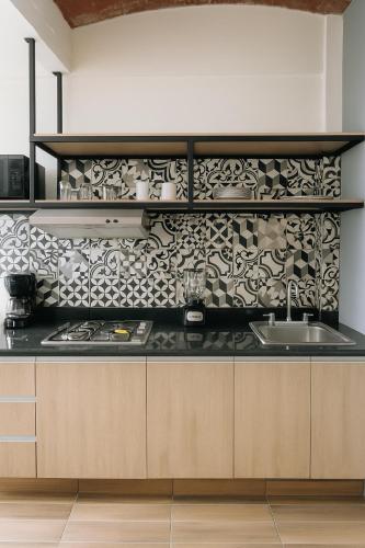 a kitchen with a black and white patterned wall at Casa Layu Oaxaca in Oaxaca City