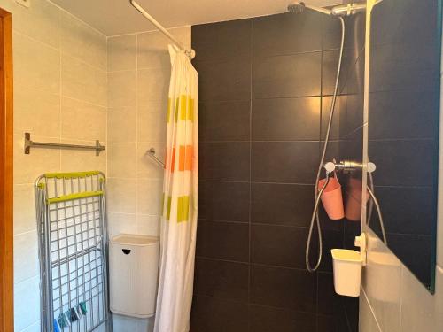 a shower with a shower curtain in a bathroom at Espacio exterior cómodo- Tu planta baja rústica - Besiberri 7 in Pla de l'Ermita