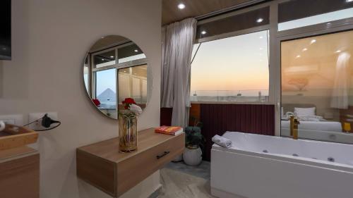 Un baño con un gran espejo y una bañera. en pyramids palace view, en El Cairo