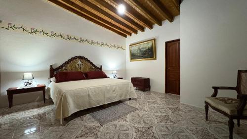 a bedroom with a bed and a chair at hotel gardenias in Pátzcuaro