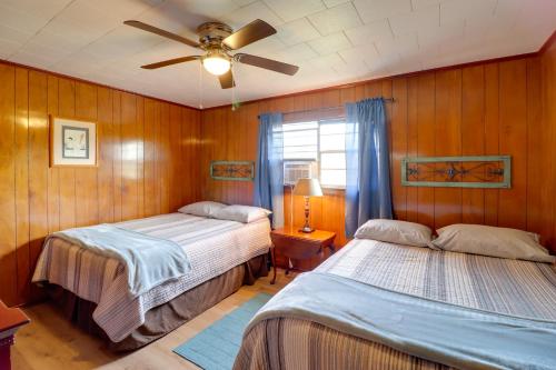 a bedroom with two beds and a ceiling fan at Pet-Friendly Cabin with Designated Boat Slip! in Fairfield Bay