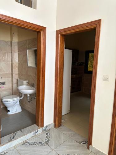 a bathroom with a toilet and a sink at Suite privée-chambre, salon et cuisine complete in Mbour