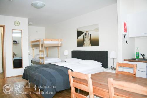 a bedroom with a bunk bed and a kitchen at South Central Apartments in Brautarholt