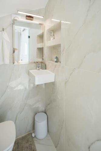 a white bathroom with a sink and a toilet at Villa Maria Cameo in Laganas