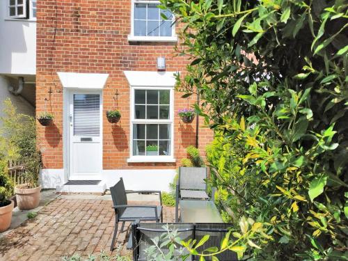 a brick house with two chairs in front of it at Colchester, Cosyquietopen Firepatiopetstrain in Wivenhoe