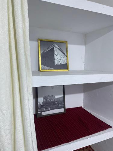 a shelf in a room with a picture and a curtain at Casona Tres Reyes in Cusco