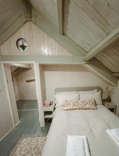 a bedroom with a large bed in a attic at The Little Welsh Cottage in Brynmenin