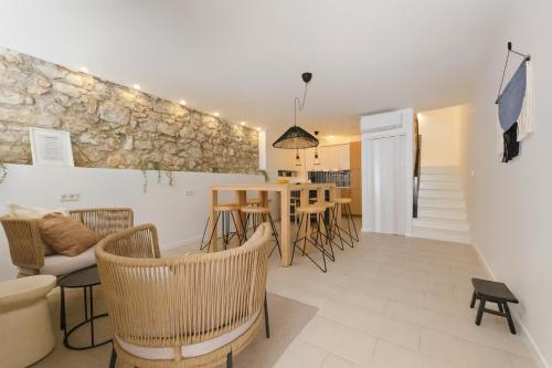 uma sala de estar com mesa e cadeiras em Stone House 4M - Stylish Coastal Stay with 3 Ensuites & Parking, Pag em Pag