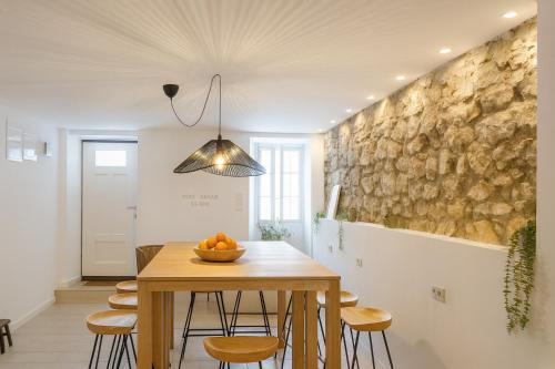 uma sala de jantar com mesa e cadeiras de madeira em Stone House 4M - Stylish Coastal Stay with 3 Ensuites & Parking, Pag em Pag