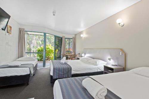 a hotel room with two beds and a window at Capricorn Motel & Conference Centre in Rockhampton