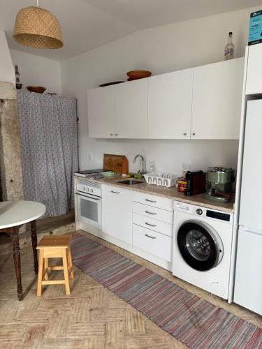 a kitchen with a sink and a washing machine at Pátio Prior do Crato 4 in Almada