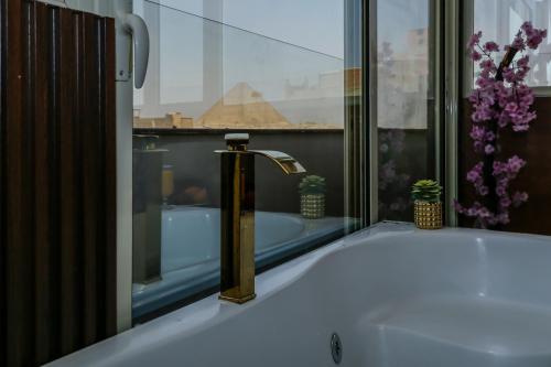 El baño incluye bañera con grifo de latón. en pyramids palace view, en El Cairo