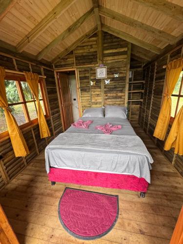 a bedroom with a bed in a wooden cabin at Finca Villa Julia - Cabañas in La Vega