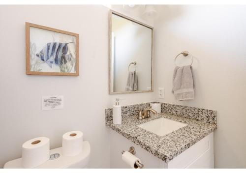 une salle de bain avec un lavabo et un miroir dans l'établissement Sunset Bellini with Hot Tub and Golf Cart!, à Bolivar Peninsula