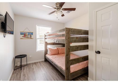 une chambre avec un lit superposé et un ventilateur de plafond dans l'établissement Sunset Bellini with Hot Tub and Golf Cart!, à Bolivar Peninsula