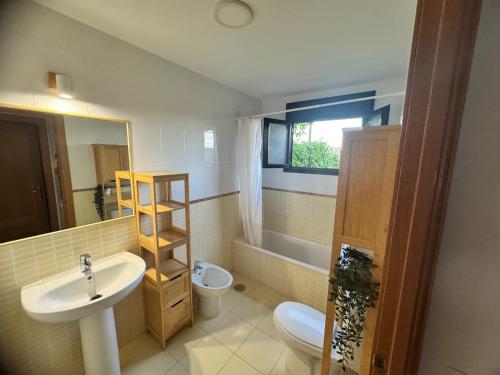 a bathroom with a sink and a toilet and a mirror at Private Terrace Majanicho Home in Majanicho