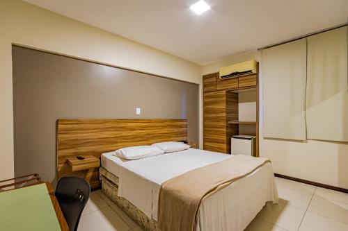a bedroom with a large bed in a room at Bevile Hotel in Cataguases