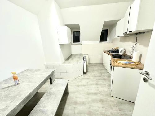 a kitchen with white cabinets and marble counter tops at Aparthotel in Chemnitz