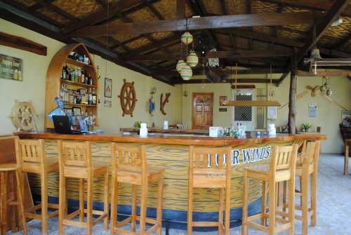 a bar in a restaurant with wooden chairs at Captain's Lodge and Bar in Panglao