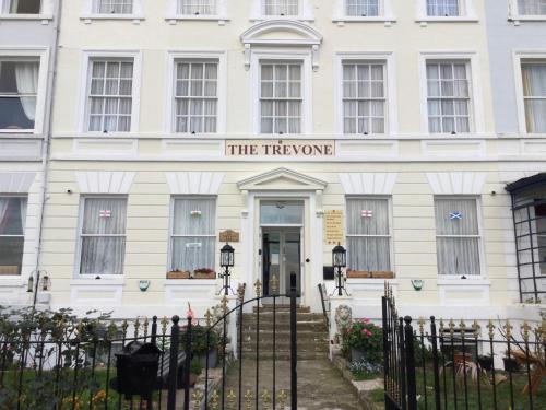 a white building with a sign that reads the treasury at THE TREVONE, Llandudno in Llandudno