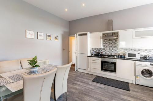 a kitchen and dining room with a table and chairs at A former school converted into a luxury apartment in Rhyl