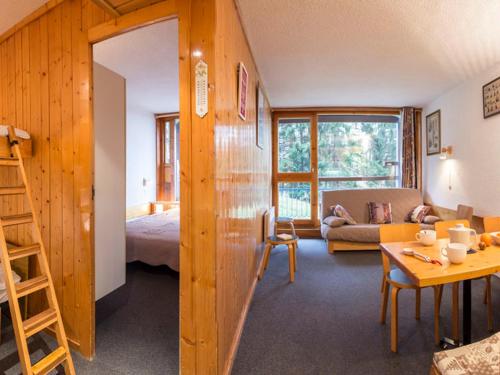 Zimmer mit einem Bett und einem Wohnzimmer mit einem Tisch in der Unterkunft Appartement 6 pers Les Arcs 1800 avec balcon et accès wifi - FR-1-346-403 in Arc 1800
