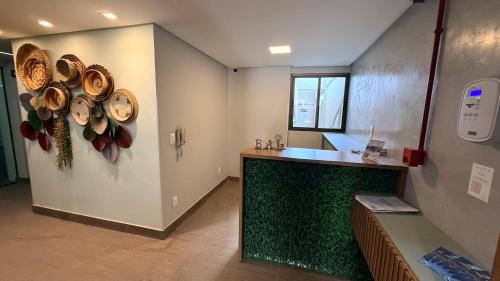 a kitchen with a counter with hats on the wall at Flat 1 quarto Beach Porto - By Duuna Temporada in Porto De Galinhas