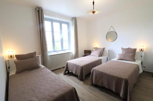 a room with two beds and a mirror on the wall at L'Oustal de Salers in Salers