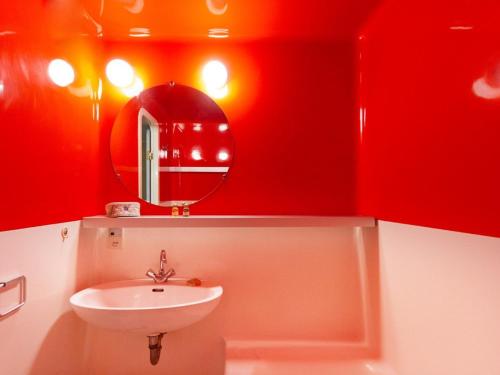 a red bathroom with a sink and a mirror at Appartement 6 pers · Balcon · Wifi gratuit · Parking - FR-1-346-559 in Arc 1800